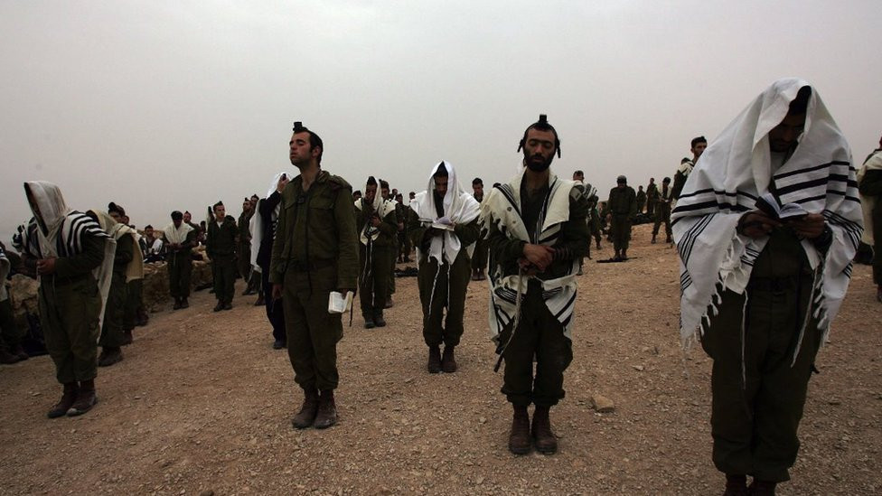 Israeli soldiers of the Ultra Orthodox battalion "Netzah Yehuda" pray on the ancient hilltop fortress of Masada in Judean desert 23 March 2007, following an all night march which is part of their graduation ceremony.