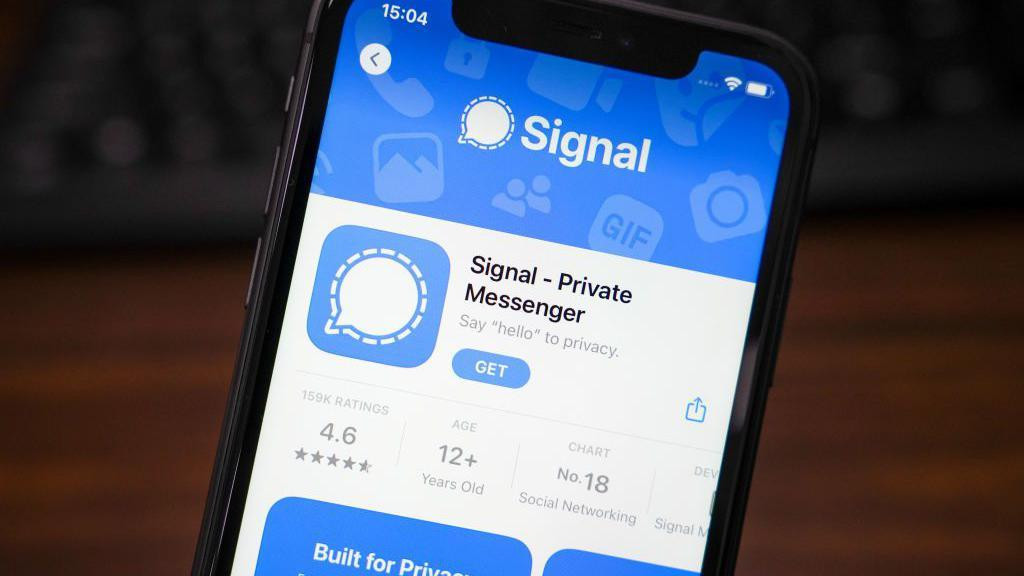
                    Ekran preuzimanja aplikacije Signal na Ajfonu. Njen logo je beli oblačić za poruke na svetloplavoj pozadini. U opisu aplikacije piše: „recite zdravo privatnosti“.
       