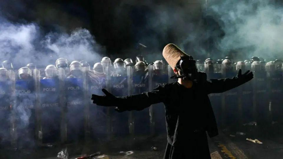 
                    A whirling dervish stands in front of Turkish riot police officers using pepper spray to disperse protesters during a rally in support of Istanbul's arrested mayor in Ist